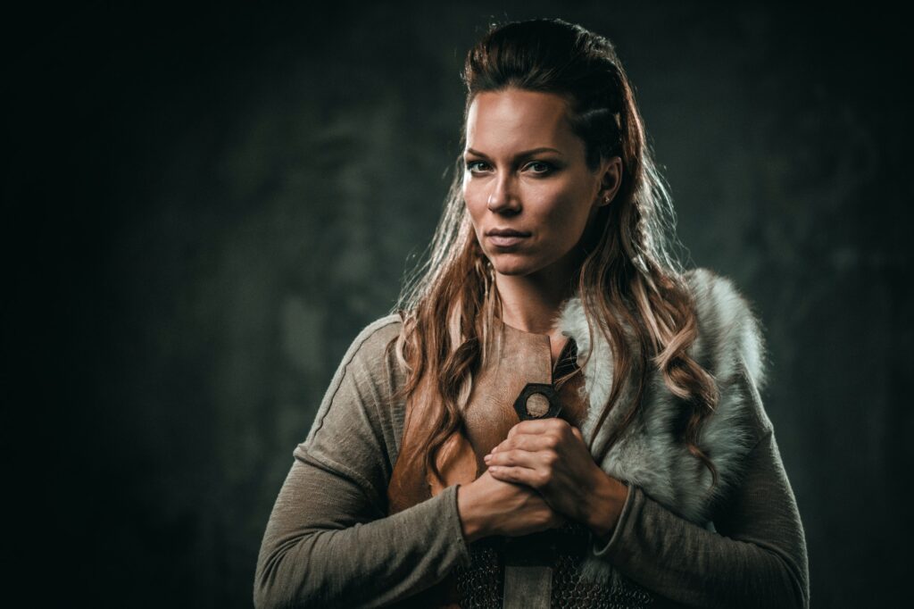 Viking woman with cold weapon in a traditional warrior clothes